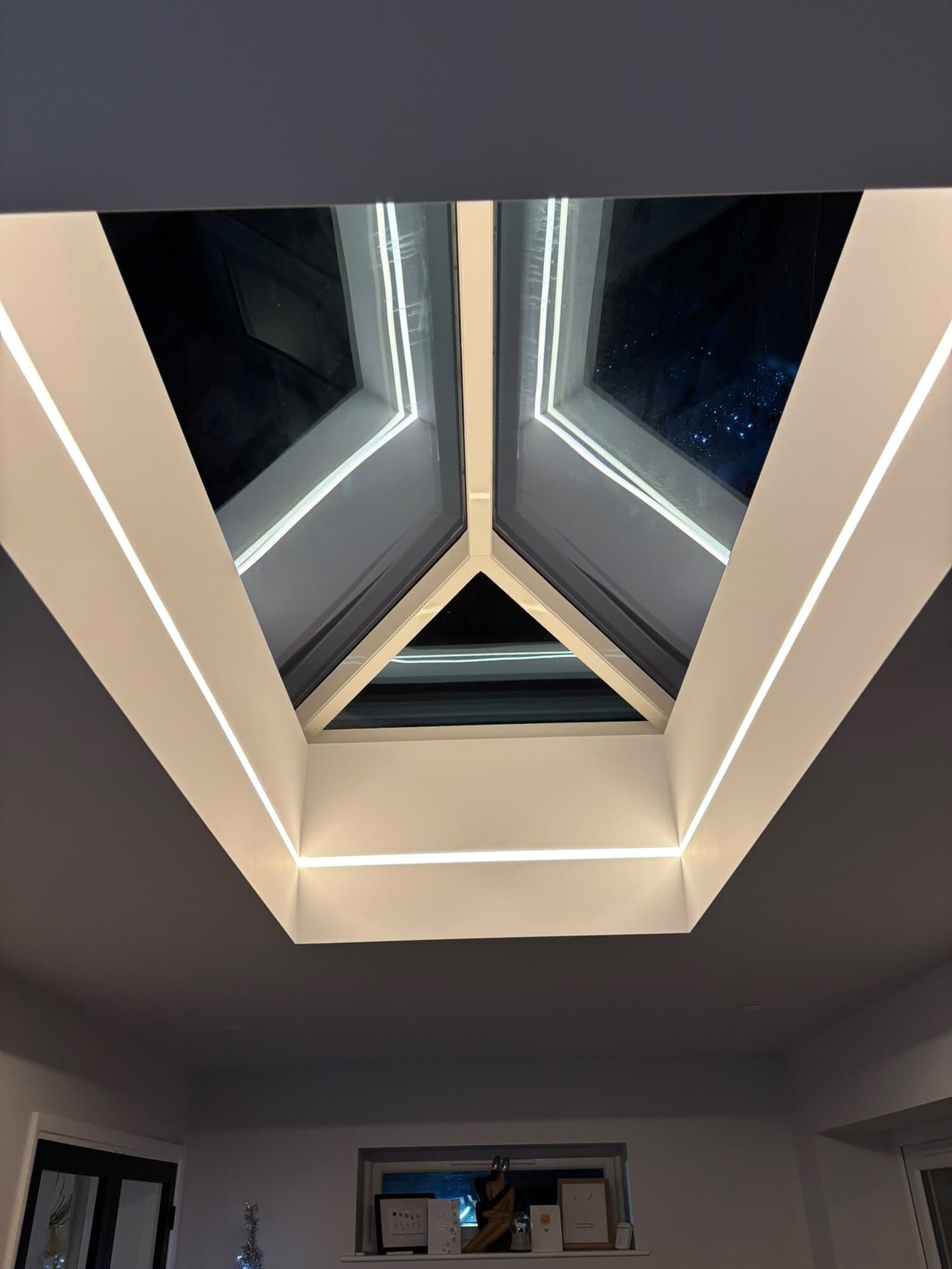 Cool white LED strip glowing around a roof lantern at night