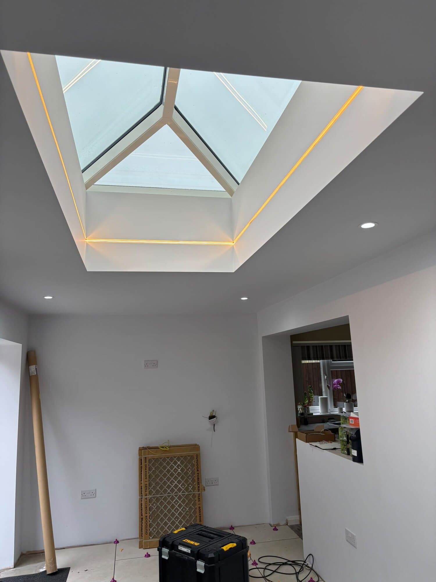 Warm white LED strip lighting fitted around a roof lantern in a new kitchen extension